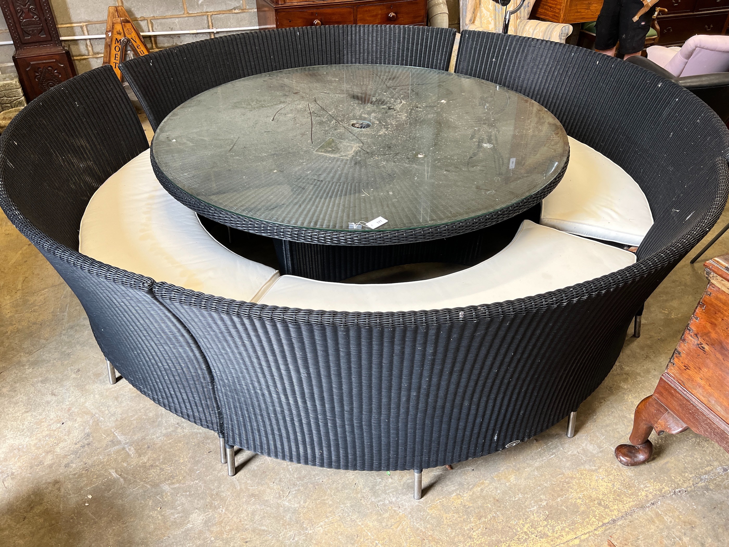 A large Westminster black all weather rattan circular topped garden table, diameter 180cm, height 74cm, together with four curved back seats and cushions